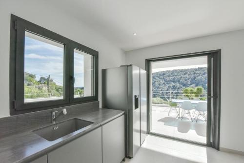 een keuken met een roestvrijstalen koelkast en een balkon bij VILLA ARTSY - Fully renovated villa with pool, AC, wi-fi - 8 ppl in Vence