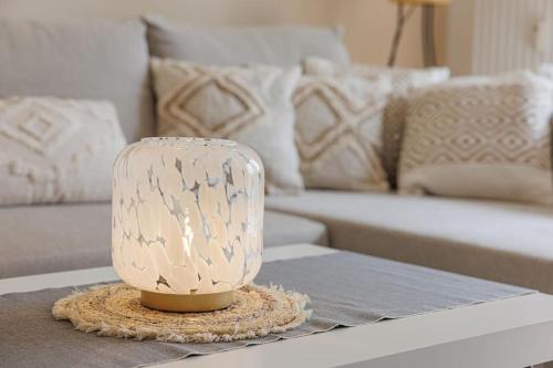eine Lampe auf einem Tisch in einem Wohnzimmer mit einem Sofa in der Unterkunft Schöne Wohnung mit Terrasse Nähe Airport in Schönefeld