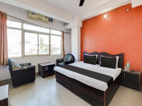 a bedroom with a large bed and two chairs at Hotel O Gp Homestay in Dehradun