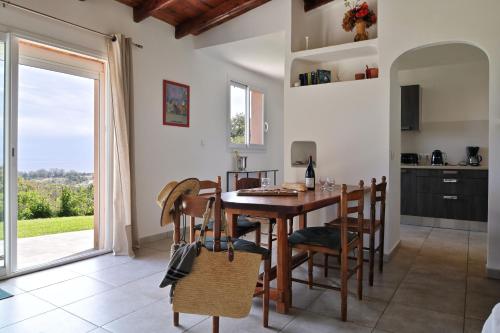 une cuisine et une salle à manger avec une table et des chaises en bois dans l'établissement Domaine Punta della Guardia villa panorama maquis et mer, plage à 1,5 Km, à Cervione