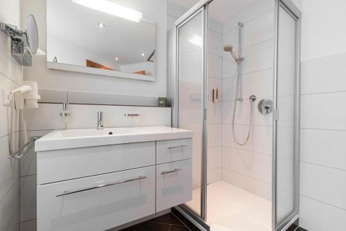 a white bathroom with a sink and a shower at EDELWEISS Ladis in Ladis