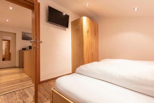 a bedroom with a bed and a flat screen tv at Edelweiss Ladis im Sommer inklusive Super Sommer Card in Ladis