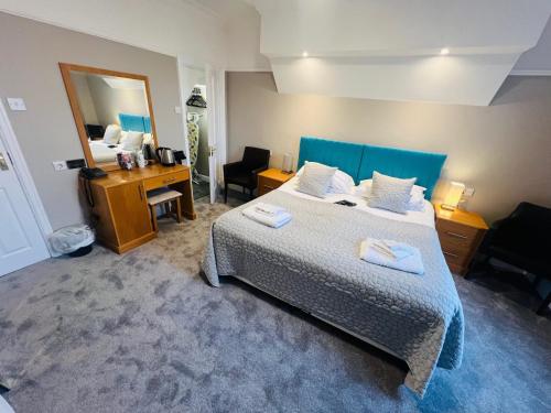a bedroom with a bed and a desk and a mirror at Hedley House Hotel & Apartments in York