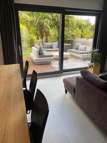 a living room with a table and a large window at Sonnendeck exklusives Haus in Meerbusch - Wellness Oase Whirlpool & Grill in Meerbusch