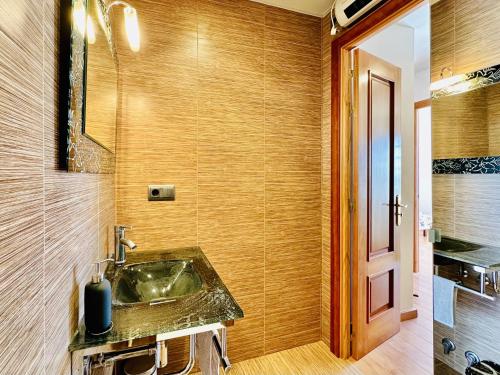 ein Badezimmer mit einem Waschbecken und einer Holzwand in der Unterkunft Cardina CostaBravaSi in Sant Feliu de Guixols