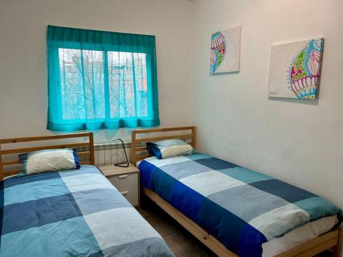 two beds in a room with a window at Céntrico apartamento bien ubicado para 5, 3 Hab in Alcobendas
