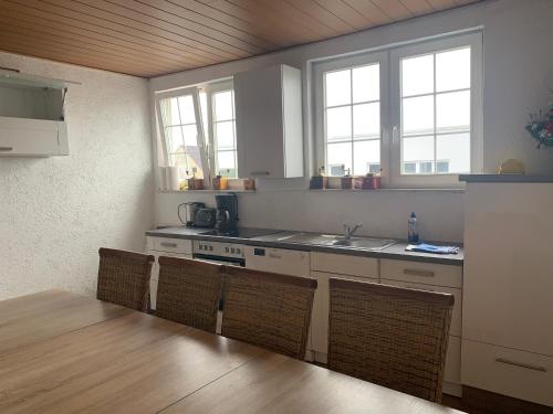 una cocina con fogones y algunas sillas y ventanas en Wohnung 3 in der 1.Etage, en Hannover