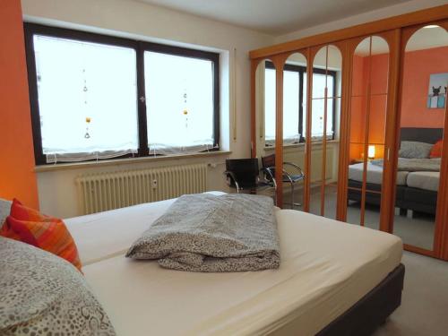 um quarto com uma cama e duas janelas em Ferienwohnung Mia em Tirschenreuth