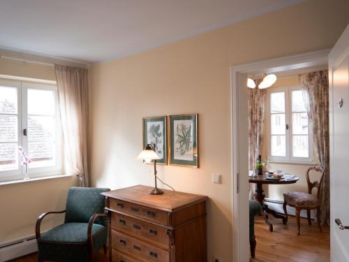 a room with a dresser and a chair and a table at REFUGIUM Theresienstraße 19 - Chambre Monet in Rhodt unter Rietburg