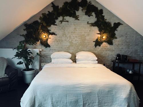 a bedroom with a bed with pillows and a brick wall at La Grainerie in Durbuy