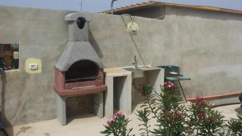 een pizza-oven in de openlucht naast een muur bij Mission Relax 1 in Lampedusa