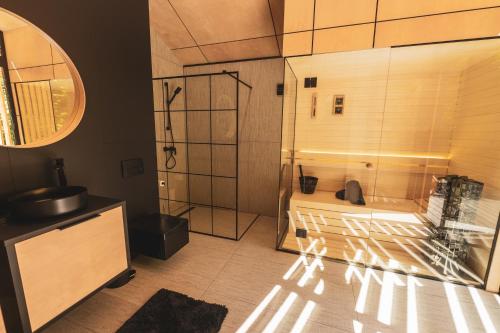 a bathroom with a glass shower and a sink at LagomHome Luxus Pihenőház ***** Noszvaj in Noszvaj