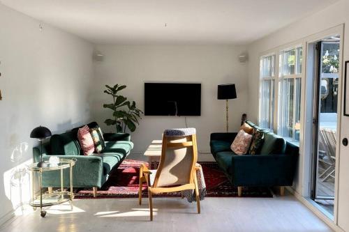 sala de estar con muebles verdes y TV en Vackert gathus i Gamla Limhamn nära Eurovision en Malmö