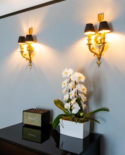 a table with two lights and a plant on it at Hôtel Gabriel Paris in Paris