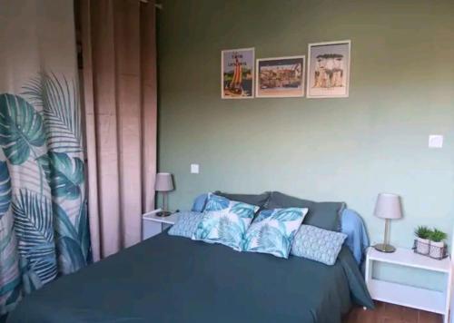 ein Schlafzimmer mit einem blauen Bett mit blauen Kissen in der Unterkunft Fred in Saint-Génis