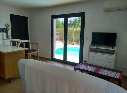 ein Wohnzimmer mit einem TV und einem Pool in der Unterkunft Fred in Saint-Génis