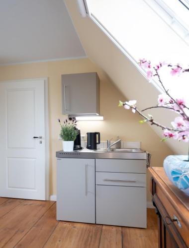 a kitchen with white cabinets and a sink at REFUGIUM Theresienstraße 19 - Chambre Slevogt in Rhodt unter Rietburg