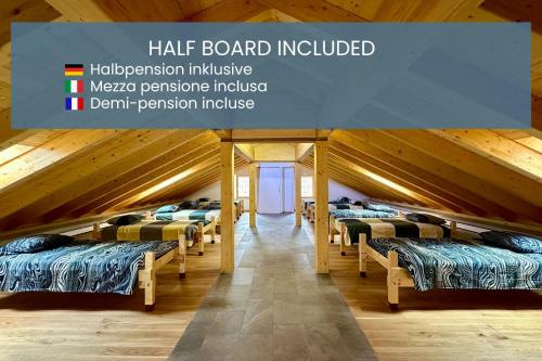 a row of beds in a room with wooden ceilings at Alpe di Caviano in Castel San Pietro