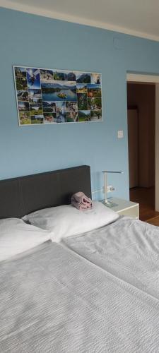 a bedroom with a white bed with a blue wall at Hacienda Bled Rooms in Bled