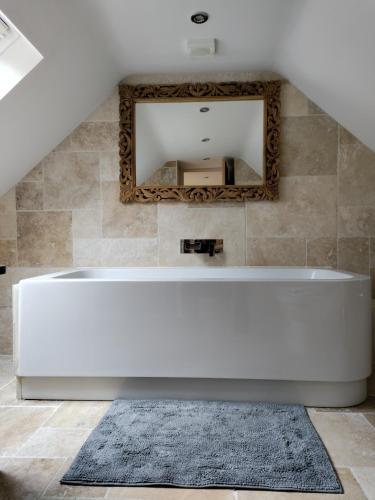 a white bath tub in a bathroom with a mirror at Best Beach 2025 "Little Haven" & The Hidden Gem in Haverfordwest