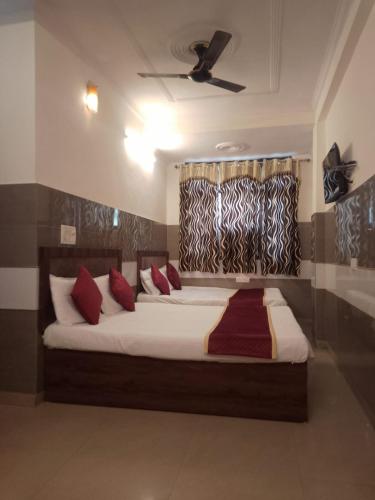 sypialnia z dużym łóżkiem z czerwonymi poduszkami w obiekcie Hotel Agarwal palace w mieście Agra
