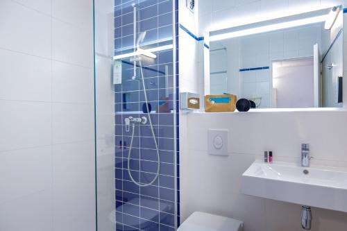 a bathroom with a shower and a toilet and a sink at KYRIAD MARSEILLE EST - Aubagne Gémenos in Gémenos