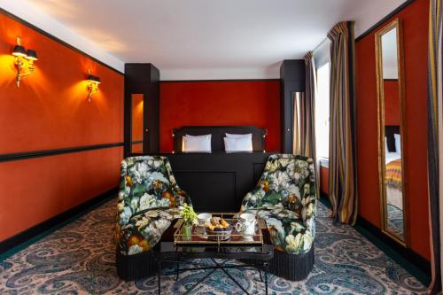 Habitación de hotel con silla y cama en Hôtel Gabriel Paris, en París