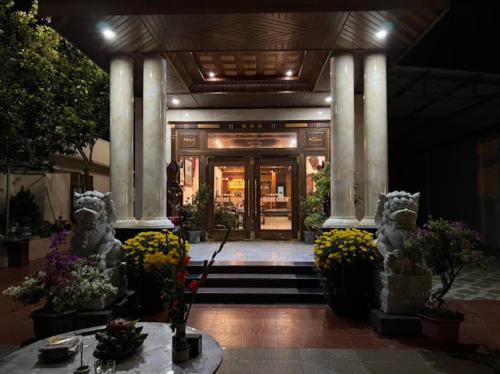 an entrance to a building with columns and flowers at Hoàng Khiêm Hotel in Pleiku