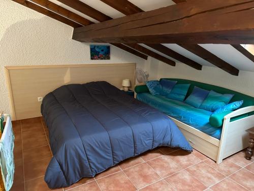 - une chambre avec un lit bleu et un canapé dans l'établissement Appartement T4 Marine de Bravone, à Linguizzetta