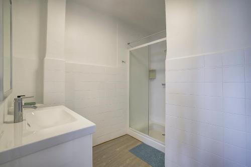 une salle de bain blanche avec un lavabo et une douche dans l'établissement Magnifique studio Le Dauphin 50m des plages, à Juan-les-Pins