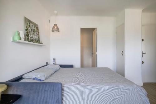 une chambre avec un grand lit blanc dans une pièce dans l'établissement Magnifique studio Le Dauphin 50m des plages, à Juan-les-Pins