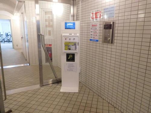 a machine in a bathroom with a tiled wall at シティラデファンス - 2025年6月室内リニューアル in Sapporo