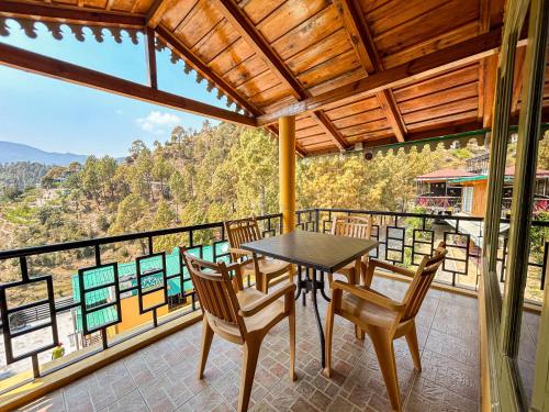 a dining room with a table and chairs on a balcony at THEHIMALAYANLIVING WHISTLING PINES in Mukteswar