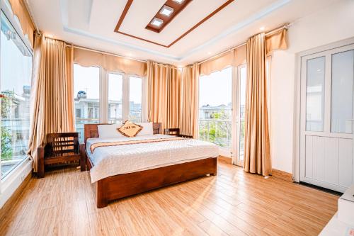 Schlafzimmer mit einem Bett und großen Fenstern in der Unterkunft Villa FLC Sầm Sơn SH20 in Sầm Sơn