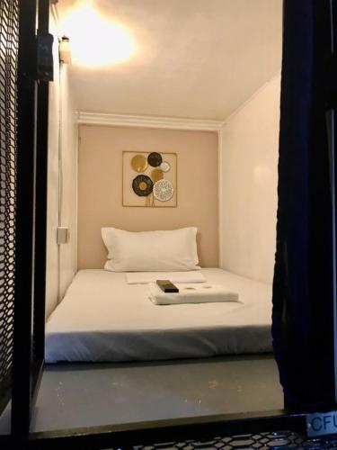 a bedroom with a bed with a book on it at Budget Transient Capsule Room Mirasol Near BGC in Manila