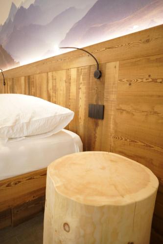a room with two beds and a table next to a bed at Mas dei Masi in Cavalese