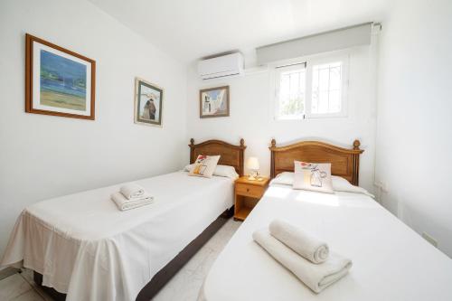 Duas camas num quarto com paredes brancas em Can Ramos em Ses Fontanelles