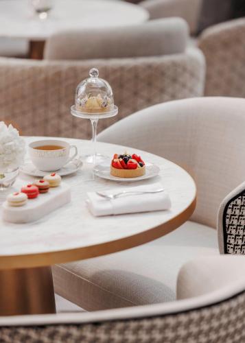 a table with a plate of food and a cup of coffee at Jumeirah Emirates Towers Dubai in Dubai