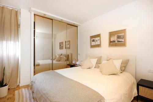 1 dormitorio blanco con 1 cama blanca grande con almohadas en Apartamento tres habitaciones en Nou Barris by Alterhome, en Barcelona