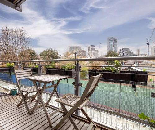 a wooden deck with a table and chairs on a balcony at GuestReady - West wapping spot near Blitz Memorial in London