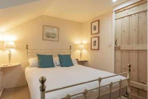 a bedroom with a bed with blue pillows at Briar Cottage in Westleton