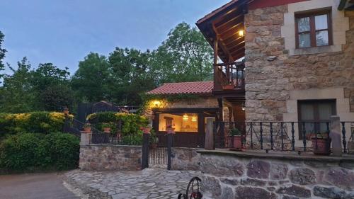 a stone house with a porch and a balcony at casa rural CABORZAL in Renedo