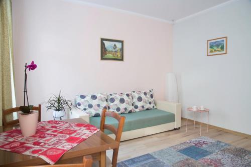 een woonkamer met een bank en een tafel bij Seek and Hide - Ilse's Hideaway in Braşov