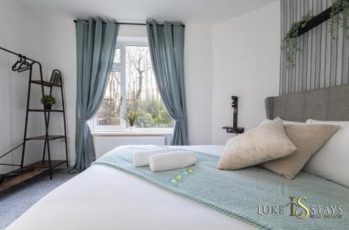 a bedroom with a bed with two pillows and a window at Luke Stays - Finchale Ave in Sheepscar
