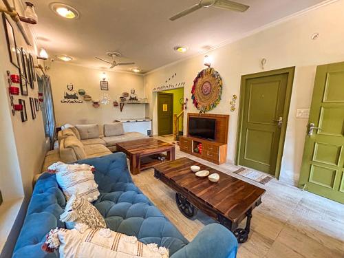 a living room with a blue couch and a table at THEHIMALAYANLIVING WHISTLING PINES in Mukteswar