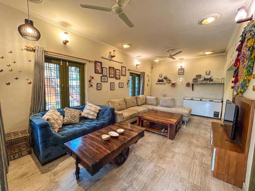 a living room with a couch and a table at THEHIMALAYANLIVING WHISTLING PINES in Mukteswar