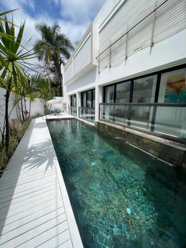 a swimming pool in front of a house at Villa moderne à Trou aux Biches in Trou aux Biches