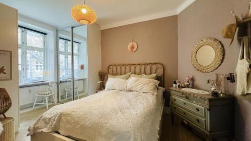 a bedroom with a bed and a dresser and a mirror at ApartmentInCopenhagen Apartment 1614 in Copenhagen