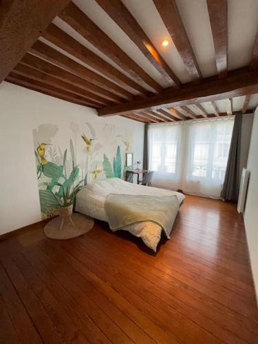 een slaapkamer met een groot bed en een houten vloer bij L' Appart cocoon in Joinville