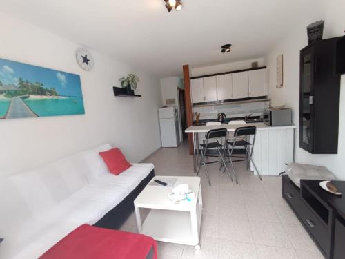 a living room with a white couch and a kitchen at Apartamento SUMMER Complex Amaya Fuerteventura in Costa de Antigua